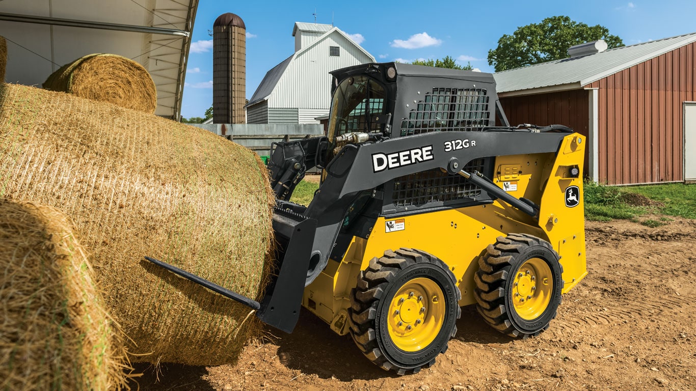 John Deere Skid Steer with Bale Spear attachment moving a bale of straw